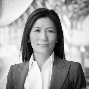 Black and white head and shoulders business portrait of an Asian businesswoman.
