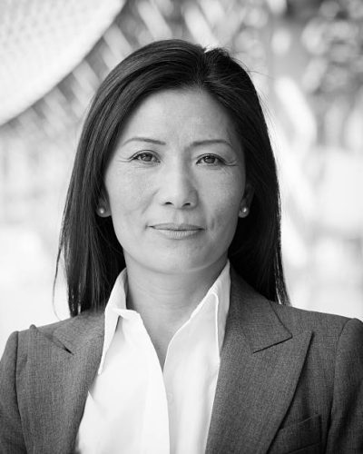 Black and white head and shoulders business portrait of an Asian businesswoman.